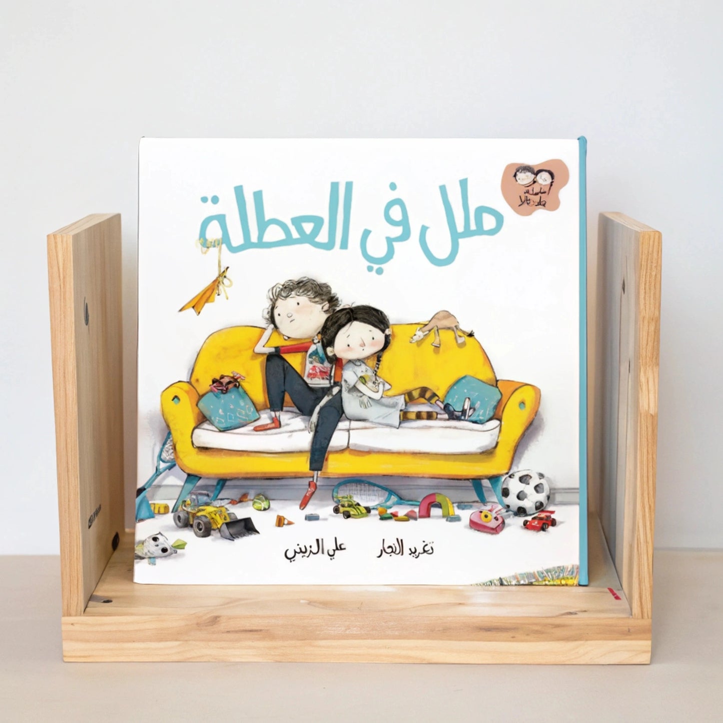 A beautifully illustrated page from an Arabic children's book, showing a mother explaining something to her two children in a cozy kitchen setting