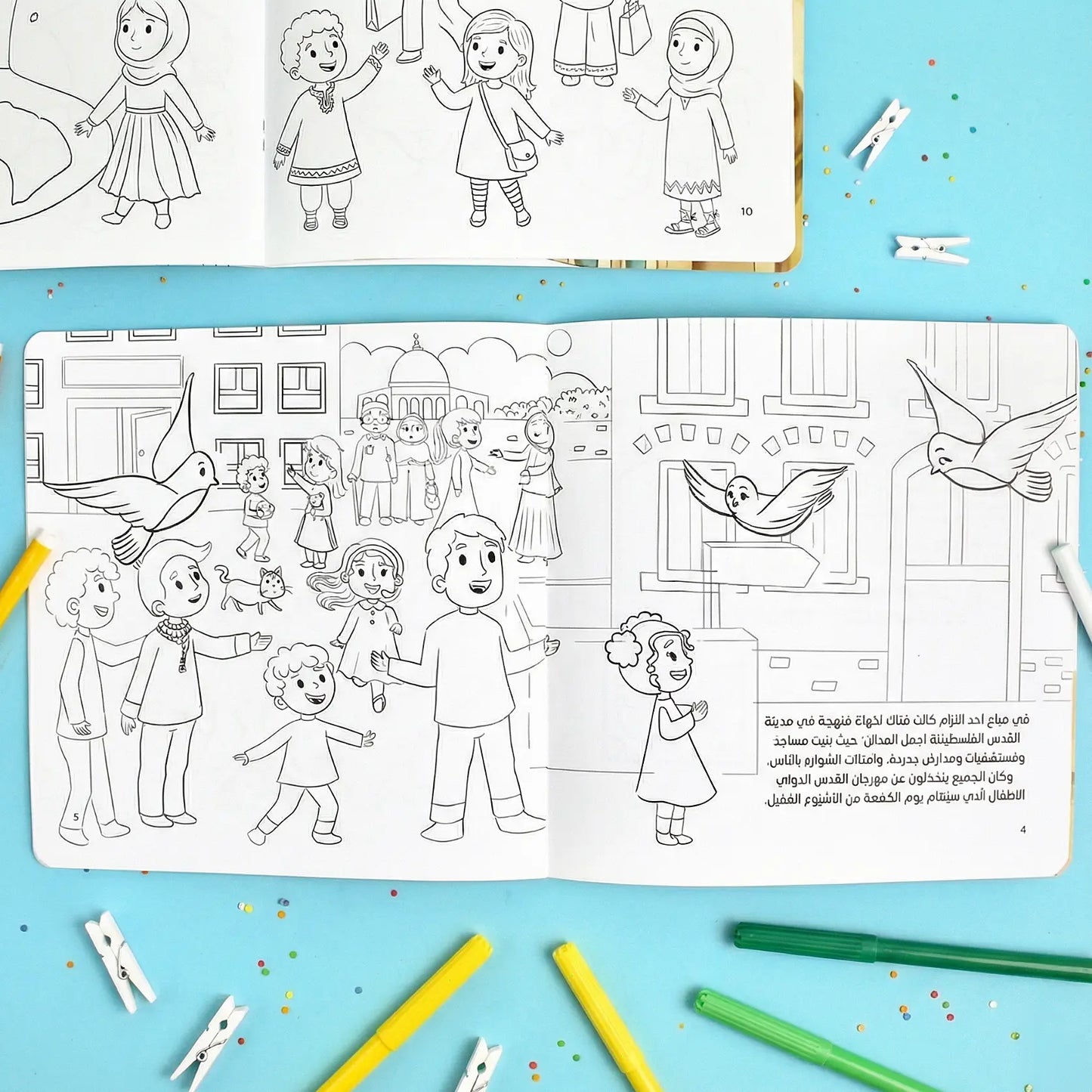 Coloring book open to a page with children and birds on a blue background with coloring supplies.