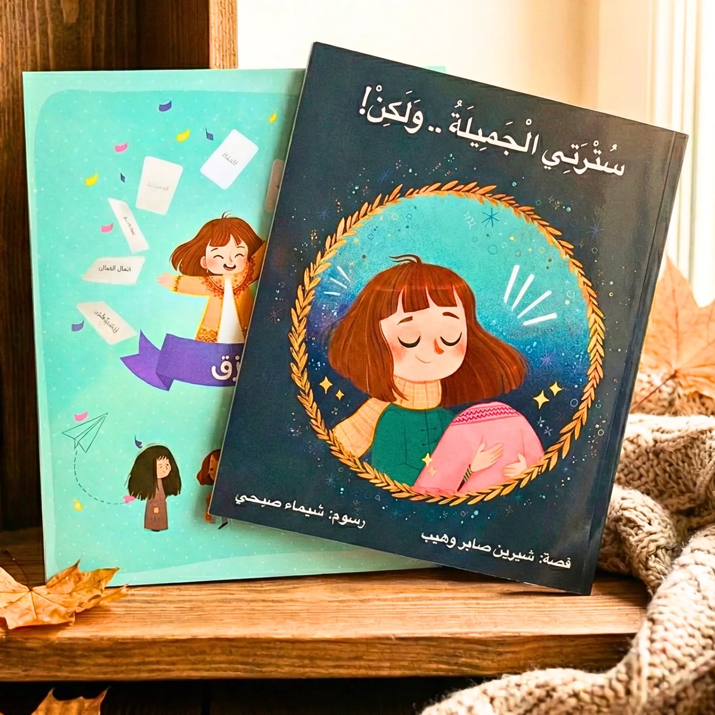 Two children's books on a wooden surface with illustrations of a girl and a boy.
