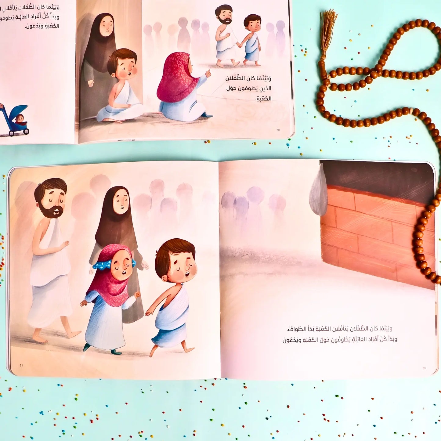 Illustrated children's book open to pages with characters and a prayer mat, accompanied by a rosary.