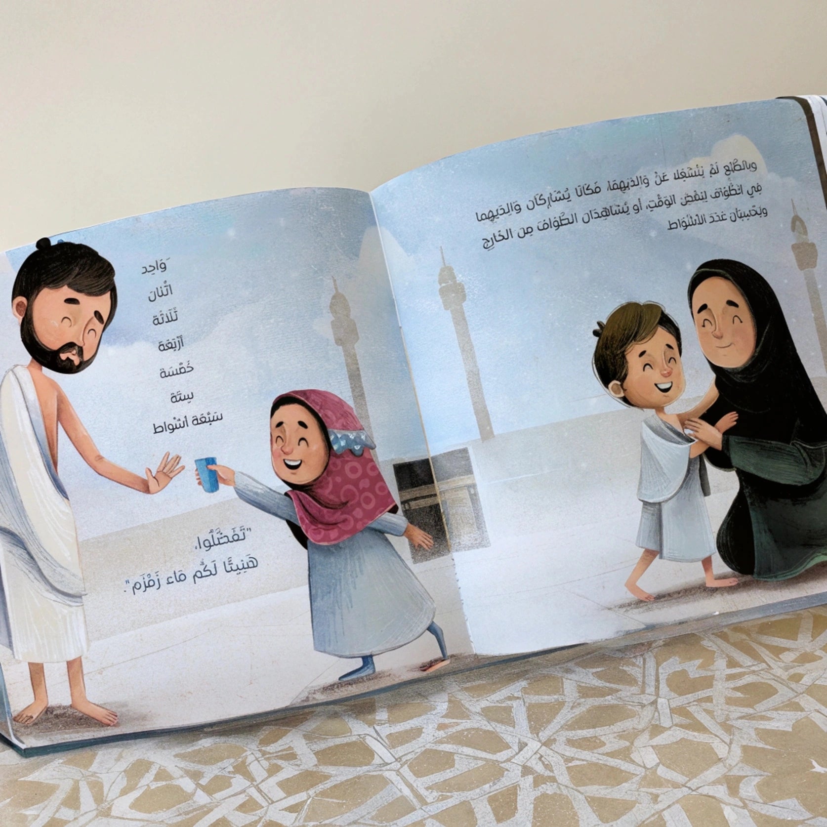 Open book with illustrated pages showing a family at a mosque.