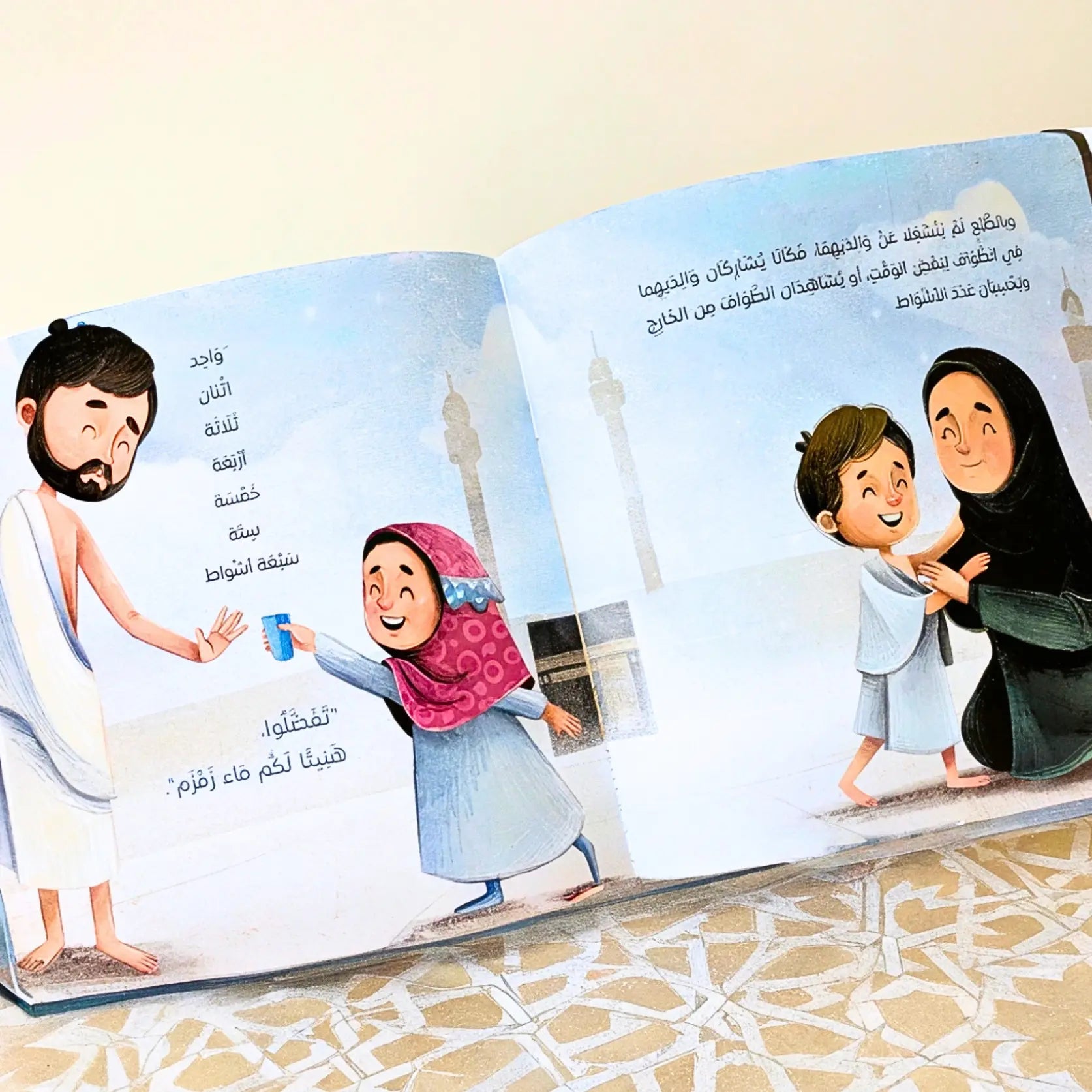 Open book with illustrated pages showing a family and a mosque on a white background